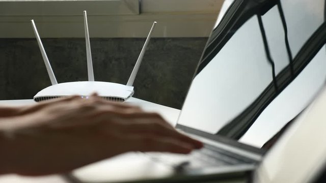 Close Up Of A Wireless Router And A Man Using Laptop On The Table 