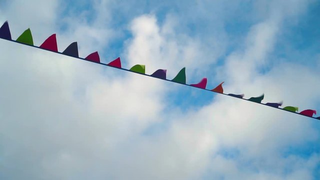 Small triangular waving flags. Colorful triangular flags waving in the wind, decoration for the holiday, outdoor.
