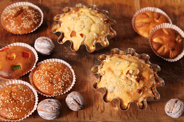 hand-made muffins and colored white walnut on the background of wooden boards