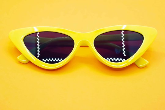 Yellow sunglasses fashion on yellow background