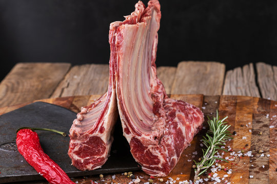 Raw lamb meat in a carnage on wooden background