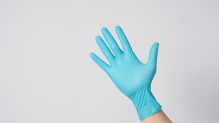 Obraz premium Right hand with blue gloves on white background.