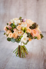 Delicate wedding bouquet of roses on the background of wooden bo