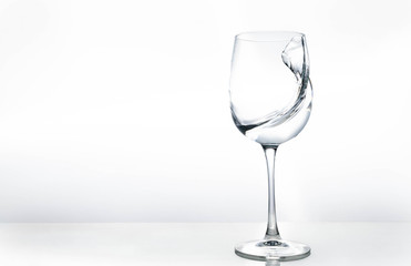 Water in a wine glass. Splash of liquid on a white background. Isolated object. Spray.