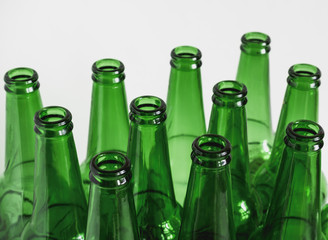 close up of green empty beer bottles on a white background