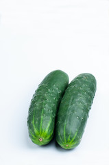 two green and fresh cucumbers on white background