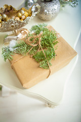 Gift in wrapping paper decorated with fresh spruce branches and tied with twine