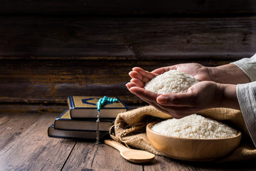 Hands are holding a pile of grain to zakat, Islamic zakat concept. Muslims to help the poor and...