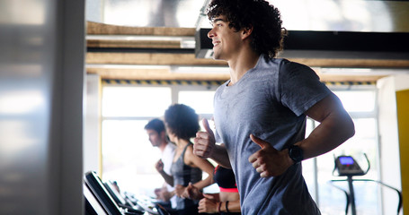 Group of fit healthy friends people cardio workout in gym