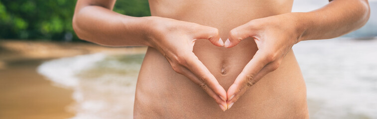 Heart shape hands on healthy stomach woman banner panoramic. Early pregnancy, probiotic digestion, healthy gut health.