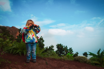 little girl with binoculars exploring nature, family on adventure