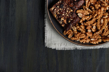 chocolate and walnut brownie next to walnuts and chocolate