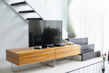 Smart TV wide screen stand on cabinet wooden in the modern living room. Concept of less is more...