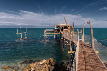 Beautiful scene of Typical fishing House on the sea. Fishing floating village on stilts, house with pier in Abruzzo.