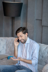 Obraz premium Laughing handsome man talking on a smartphone.