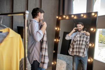 Man talking on a smartphone looking in the mirror.