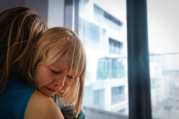 sad crying little girl hugging mother indoors, kids anxiety and stress