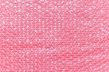 Pink bubble wrap air filled transparent packaging foil placed on pink backgound.