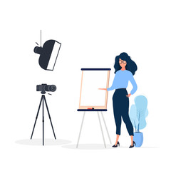 The girl is giving a presentation in front of the camera. The teacher conducts a lesson online. The concept of blogs, online training and conferences. Camera on a tripod, softbox.