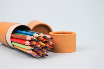 Fototapeta premium Close up of paper tubes with color pencils inside on light grey background with copyspace. Reusable packaging and recycling concept showing how to reuse cardboard packaging at home. Mockup