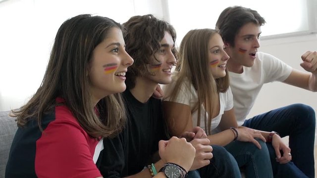 Young people supporting German national team on tv