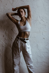 Sexy woman with tattoos wearing cotton bra and white jeans