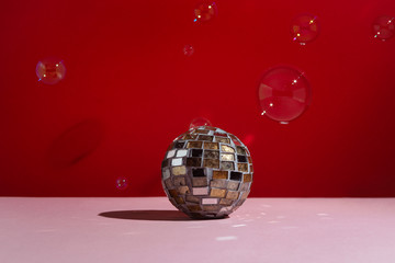 Disco ball on pink background with soap buble around, selective focus