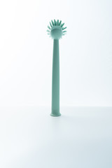 A green brush is placed on a white background. Kitchen dishwashing brush on white background.