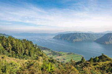 Naklejka na ściany i meble View from the island of Samosir to Lake Toba, the largest volcanic lake in the world situated in the middle of the northern part of the island of Sumatra in Indonesia