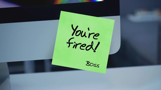 Sticky notes. You're fired. The inscription on the sticker on the monitor. Financial crisis, business crash. Dismissal during quarantine. Unemployment. Message. A message for an employee. 