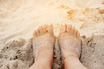 Female legs on sand texture.