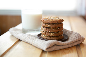 oatmeal cookies with a glass of milk on a wooden table