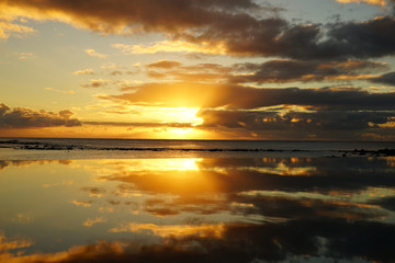 Sunset by the beach and reflection on the water