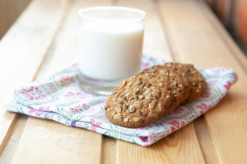 oatmeal cookies with a glass of milk on a wooden table