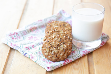 oatmeal cookies with a glass of milk on a wooden table
