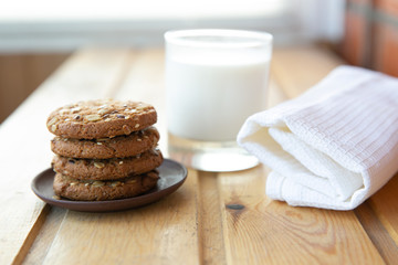 oatmeal cookies with a glass of milk on a wooden table