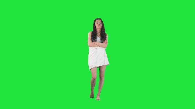 Offended young woman in white towel annoyed showing talk to the hand gesture. Full body pre keyed on green screen chroma key background