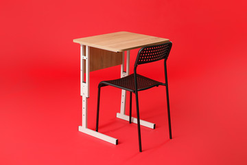 School desk with chair on color background