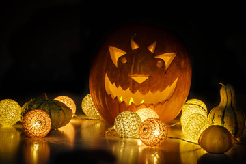 Helloween pumpkin with candles on black background. Large, out of focus helloween symbol. Selective focus