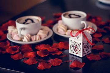 gift box and coffee cup with steam and rose petals