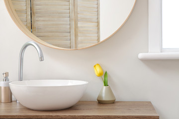 Interior of bathroom with fresh tulip flower