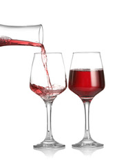 Pouring of wine from decanter into glass on white background