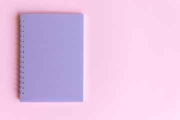 Colorful photography with purple notebook on pink background and free space for text, mock-up. Top view. Learning to draw, making wish list, events or plans.