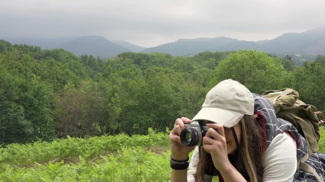 Young woman taking pictures during walk in nature