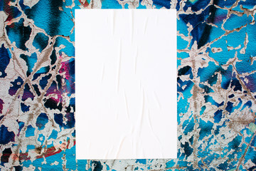 Closeup of colorful messy painted urban wall texture with wrinkled glued poster template . Modern mockup for design presentation. Creative urban city background.