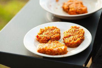 Barbecue and homemade food concept.   Burger cutlet for grill on the white plate. Close up. Space for a text. 