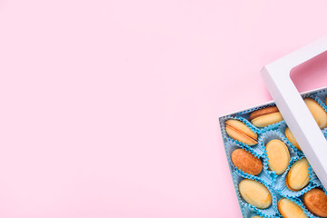 Homemade Russian nuts with condensed milk on a light pink background, wafer napkin. Cut nuts with condensed milk. Bitten goodies for coffee. Condensed Nuts