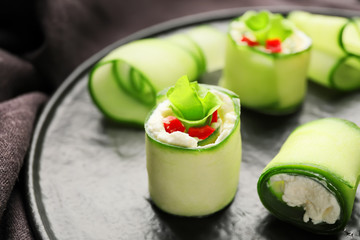 Plate with tasty cucumber rolls, closeup