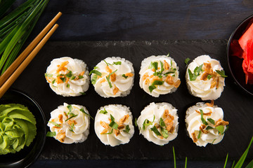Set of sushi rolls with wasabi and ginger on a black background. Japanese oriental cuisine