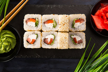 Set of sushi rolls with wasabi and ginger on a black background. Japanese oriental cuisine